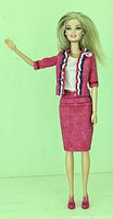 Full body image of Barbie doll in red skirt suit with original shoes and political pin.