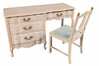 Desk and matching chair with French Provincial style, showing front and left views, light distressed finish, brass hardware, scalloped edges, and cushioned chair seat.