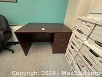 Full view of the dark brown desk showing workspace and drawers