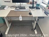 Full view of the adjustable height desk with computer setup and visible digital height control panel.