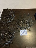 Photo showing three round wire baskets placed on a dark surface, displaying their open wire grid design.