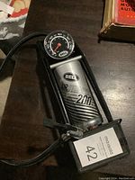 Bell Airstomper 2000 air foot pump with pressure gauge, mounted on metal frame with rubber hose and inflation nozzle.