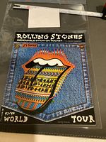 Front photo of Rolling Stones removable stick-on pocket patch in original packaging showing denim pocket design with colorful tongue and lips logo and World Tour 97/98 text.