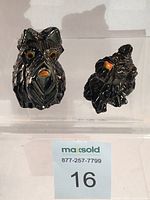 Front view of two black Scottie dog figurines on clear stands with seller lot tag in front.