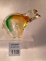 Front angle showing colorful polar bear paperweight with orange and green hues inside clear glass.