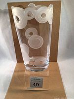 Front view of clear glass vase with wide top, showing frosted circular etched design around upper rim and midsection.