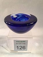 Front angled view of the cobalt blue glass votive holder showing overall shape and thickness of glass.