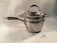 Photo of the set assembled with steamer basket inside pot and glass lid on top, showing polished stainless steel finish and handles.