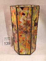 Front and side view of hexagonal leaded stained glass vase with autumn leaf design on amber colored glass panels.