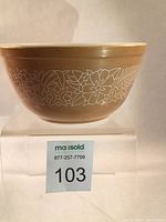 Side view of the Pyrex Woodland pattern mixing bowl showing the floral white foliage design on a medium brown background.