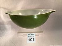 Side view of the green exterior and white interior showing the spout and overall shape of the Pyrex mixing bowl.