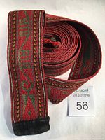 Full view of the rolled antique wool belt showing length, texture, and leather end.