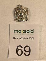 Top view of the sterling pendant displayed with a MaxSold tag for scale.