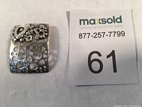 Close up of pendant beside lot number card to show size and detail.