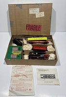 Original mail-in box opened showing train set contents packed with paper.