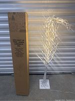 Photo of Purcell LED light up Christmas tree next to original box showing product and size.