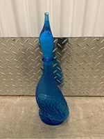 Side view of the blue textured glass decanter showing the shape and stopper.