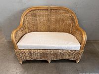Front view of woven rattan wicker loveseat with seat cushion