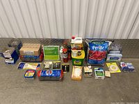 Wide view of multiple plant and home supplies on metal background including perlite bag, fertilizer, gloves, tape, and plant food