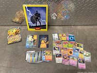 Overview of Pokemon cards, Pikachu art prints, large Pikachu card and PSA Batman card