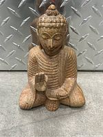 Front view of the stone Buddha statue showcasing detailed carving and seated posture