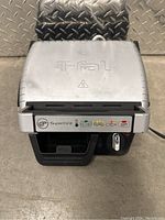Closed view of T-fal Super Grill showing the top lid with brand logo and control panel with dial and indicator lights.