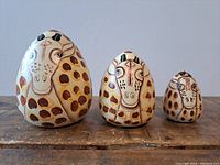 Three giraffe stacking nesting dolls in small, medium, large sizes shown from front.