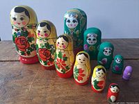 Two sets of Russian stacking dolls displayed side by side on a wooden surface, showing all dolls from largest to smallest, varied colors and floral hand painted decoration.