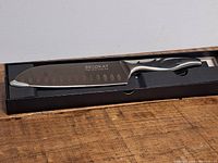 Becokay kitchen chef's knife in original box on wooden surface.