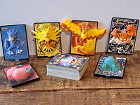 Close-up view of six pop-up 3D Pokemon display cards featuring Zapdos, Moltres, Dewgong, Machop, and two others positioned on a table.