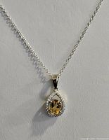 Front close-up photo of the sterling silver necklace pendant with citrine gemstone and surrounding cubic zirconia stones.