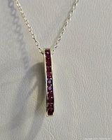 Close-up photo of the vertical pendant showing heated red ruby stones set in rhodium plated sterling silver.