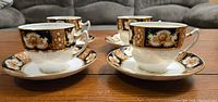 Four Royal Albert Imari style teacups paired with matching saucers, showing the detailed decoration and elegant shape.