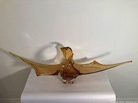 Full front view of the large amber chalcedony glass sculpture on a white background.