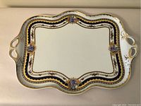 Top view of the rectangular porcelain tray showing ornate gold, navy, and floral decoration with classical figure medallions.