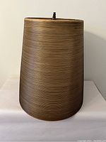 Full view of conical lampshade showing shape, finish, and finial