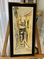 Front view of framed signed oil impasto painting depicting European street scene, showing texture, colors, and signature.