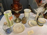 Overview of assorted lamps, glassware, and ceramics including Lenox dish, oil lamp, assorted cups, bowls and jar.