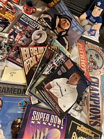 Collection of New England Patriots magazines, yearbooks, and memorabilia covering team history and players including Tom Brady.