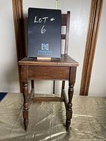 Front view of antique wooden chair showing turned legs and front apron.