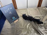 Photo showing Heather Stealth Pro aquarium heater with power cord coiled beside a lot sign.