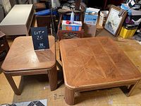Both the coffee table and end table set side by side on a floor with a blackboard marked lot 25 between them. Photo shows wood grain pattern and table structure.