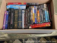 Top view of the box showing DVDs including The Incredibles, Lord of the Rings box set, Pirates of the Caribbean, and other titles