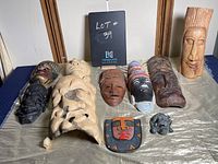 Photo of nine assorted decorative masks arranged on a grey cloth surface showing a variety of materials and styles