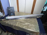 Full view of rolled Mylar reflective film on a cylindrical core, stretched out over a surface, with the reflective material visible beneath the roll