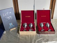 Photo showing two original Royal Selangor cases each containing two pewter goblets on a table with lot number sign