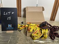 Lot 18 sign next to box containing yellow and black/red ratchet straps