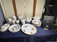 Full view of set on table with plates, platters, casseroles, pitchers and coffee pot