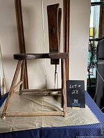 Side view of antique wooden saddler's bench showing structural details and clamp mechanism.