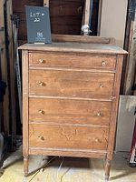 Front view of vintage high boy wooden dresser with four drawers and round wooden knobs, showing natural wood grain and minor wear